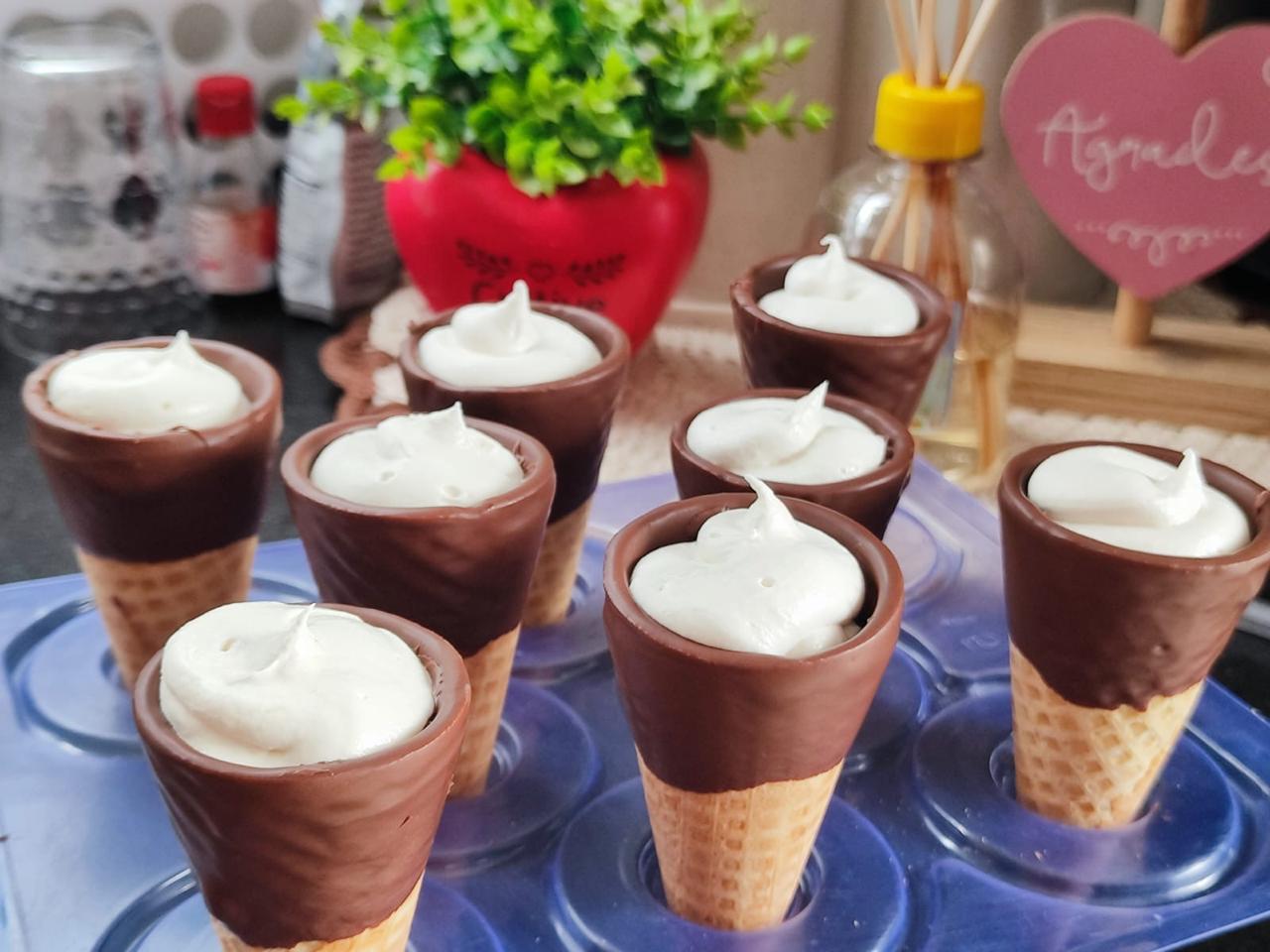 Cones de chocolate com creme branco em forminha